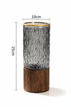 Decorative vase with textured design and wooden base, shown with measurements on a surface.